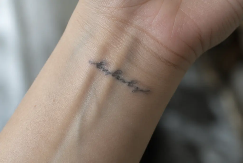 A few-year-old piece of tiny handwritten script up close: the inner spaces of the letters are starting to fill in and the edges of the lines have softened.